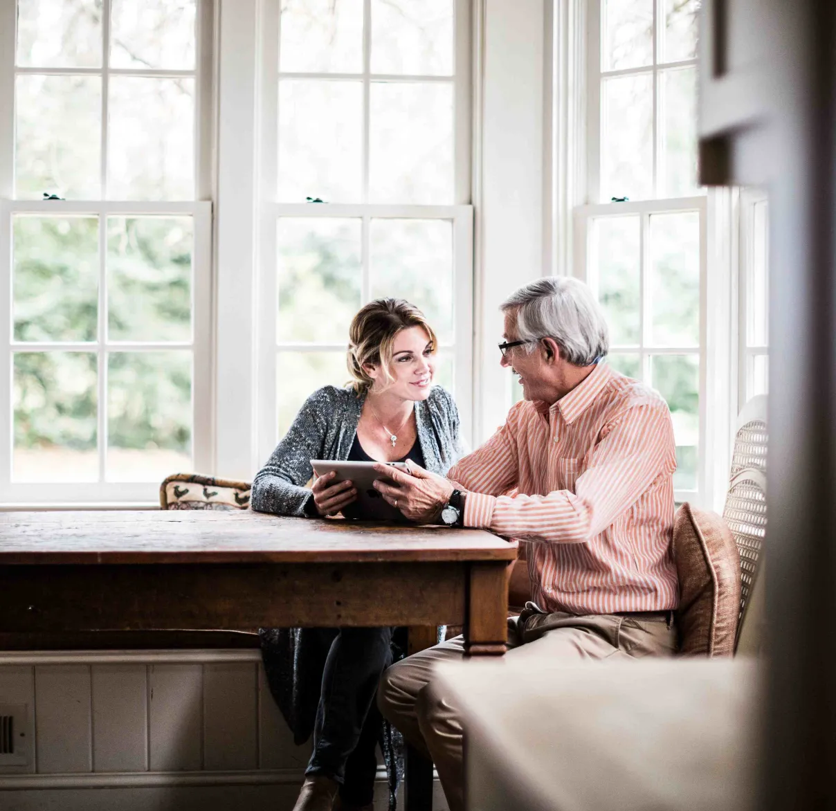 A father and daughter discuss something on an iPad