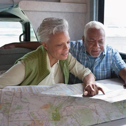 a couple planning their retirement adventure looking at a map